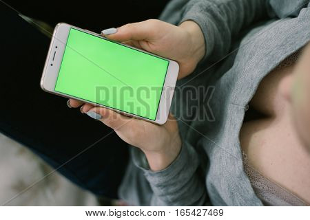 Beautiful girl holding a smartphone in the hands of a green screen green screen, hand of man holding mobile smart phone with chroma key green screen on white background, new technology concept