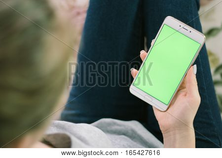 Beautiful girl holding a smartphone in the hands of a green screen green screen, hand of man holding mobile smart phone with chroma key green screen on white background, new technology concept