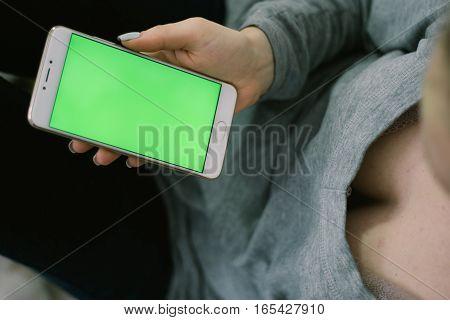 Beautiful girl holding a smartphone in the hands of a green screen green screen, hand of man holding mobile smart phone with chroma key green screen on white background, new technology concept