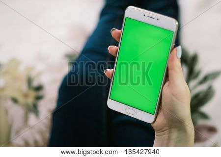 Beautiful girl holding a smartphone in the hands of a green screen green screen, hand of man holding mobile smart phone with chroma key green screen on white background, new technology concept