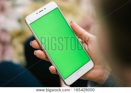 Beautiful girl holding a smartphone in the hands of a green screen green screen, hand of man holding mobile smart phone with chroma key green screen on white background, new technology concept
