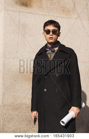 MILAN ITALY - JANUARY 14: Fashionable man poses outside Antonio Marras fashion show building during Milan Men's Fashion Week on JANUARY 14 2017 in Milan.