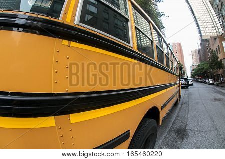A yellow school bus in the street seen through a fisheye lens.
