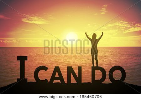 Silhouette young woman standing and raising up her hand about winner concept at I CAN DO text over a beautiful sunset or sunrise at the sea. background for success in 2017 years .hope to business success
