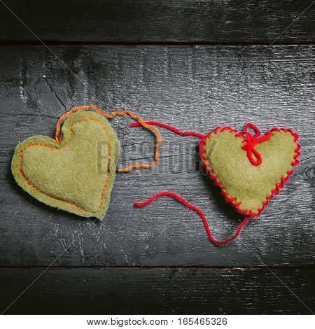 Valentine's Day. Colorful knitted hearts. Red heart on the dark boards. Valentines day. Heart pendant. Red heart. Valentine cards. Space for text. Toning dark colors.