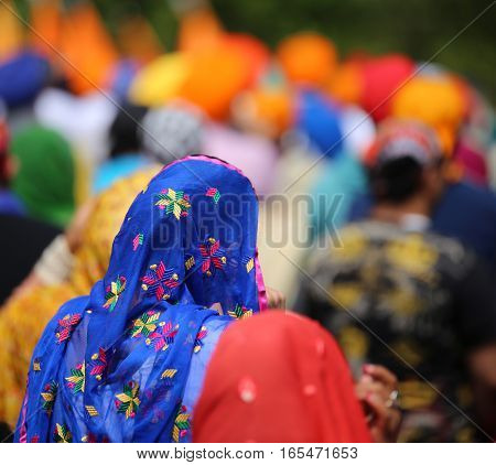Woman Wearing Blue Veil Headdress During A Gathering Of People