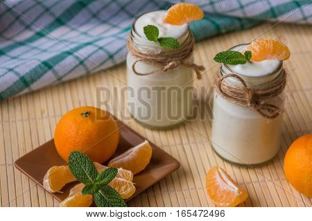 Fresh Organig Natural White Yogurt In Glass Jars With Tangerine And Mint