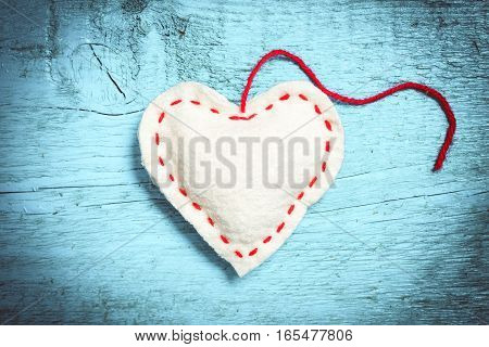 Valentine's Day. Colorful knitted hearts. White heart on the light blue boards. Valentines day. Heart pendant. Red heart. Valentine cards. Space for text. Toning in bright colors.