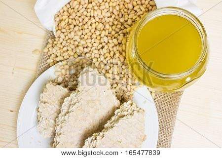 Food for vegans. The pine nuts in a white cotton bag, cedar oil is cold pressed and a cake of pine seeds on a wooden vintage texture. The view from the top. Delicacies from Siberia