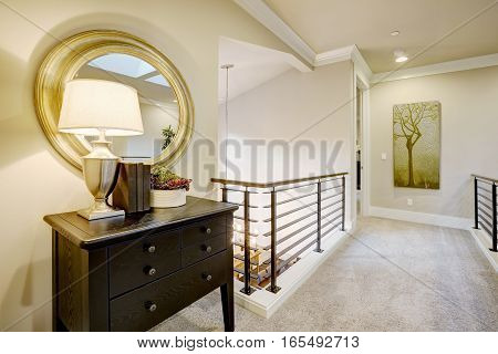 Second Floor Landing With Black Console Table And Round Gold Mirror.