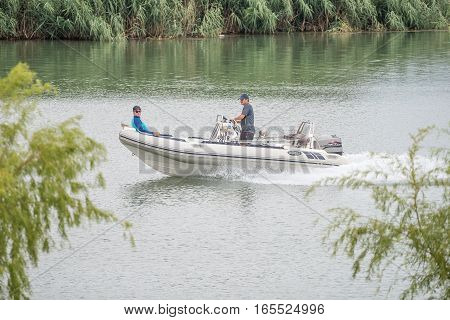 RITCHIE SOUTH AFRICA - DECEMBER 30 2016: Two unidentified people in a boat on the Riet River (reed river) at Ritchie a small town in the Northern Cape Province