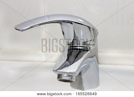 the metal sanitary water tap in bathroom