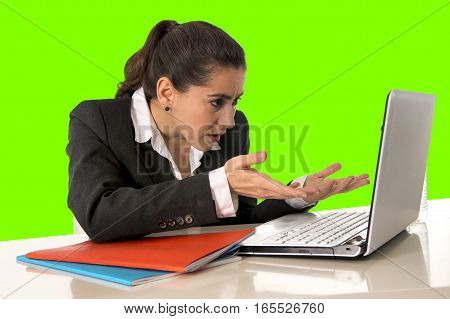 overworked hispanic business woman wearing business suit working on laptop computer looking stressed and worried in woman facing work problem concept isolated on green chroma key screen background