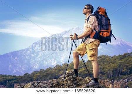 Summer hiking in the mountains with a backpack .