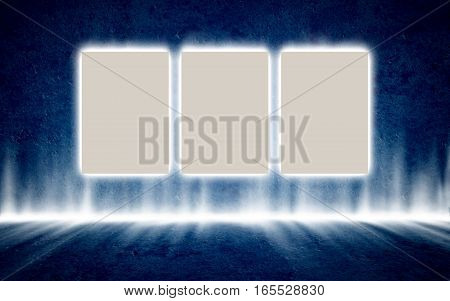 Three backlit posters in mysterious glowing interior hanging on the dark blue concrete wall. Background, template, mock up