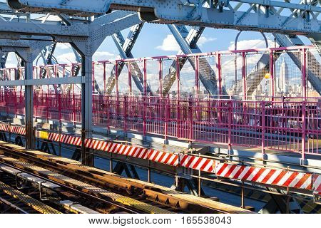 Scenic view of the Williamsburg Bridge subway tracks and pedestrian walkway with Manhattan skyline in background in New York City