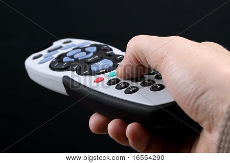 Mano che tiene il telecomando cambiando canali su una tv