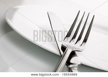 Placa de china blanco con cruzado plata cuchillo y tenedor cubiertos, baja profundidad de campo