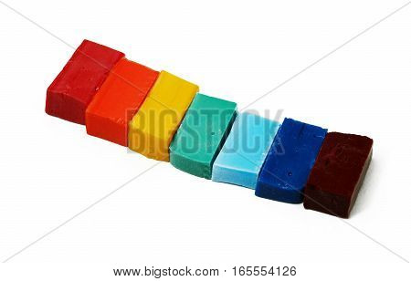 Smalt tiles of different colors arranged in rainbow order on white background