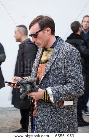 MILAN ITALY - JANUARY 15: Fashionable man poses outside Damir Doma fashion show building during Milan Men's Fashion Week on JANUARY 15 2017 in Milan.