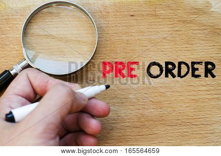 Human hand over wooden background and pre order text concept
