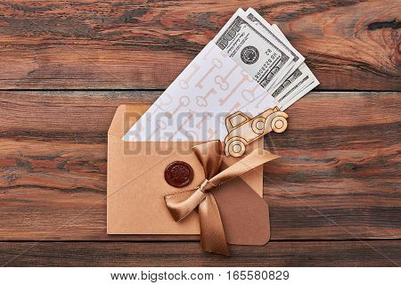 Money in envelope with seal. Key print paper near bow. Money is base of economy.