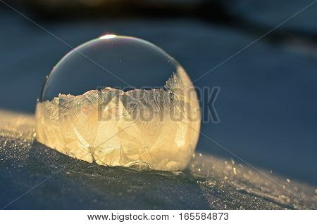 Frozen soap bubble. Cold winter liquid ball experiment. Freezing water with icy patter texture