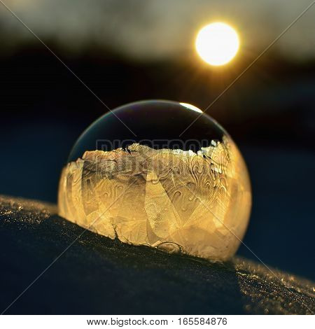 Frozen soap bubble. Cold winter liquid ball experiment. Freezing water with icy patter texture