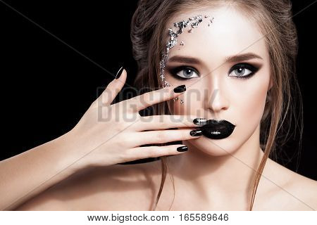 Beauty Woman Portrait. Professional Makeup and Manicure with siver foil glitter, smokey eyes. Black colors. Copy-space. Studio