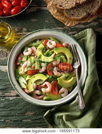 A delicious coldwater shrimp and avocado salad with tomato cucumber celery green onion cilantro and dill.