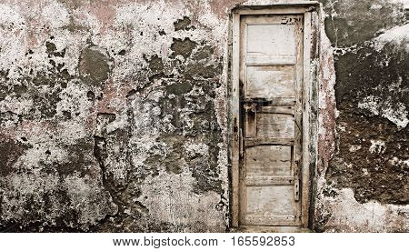 Old wooden door on a old cracked old wall full textured