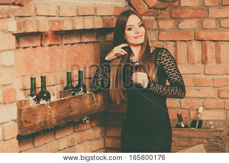 Woman Tasting Wine In Rural Cottage Interior