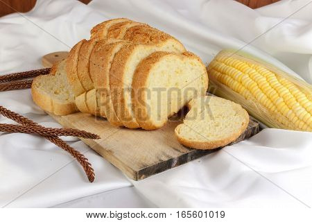 bread made from corn on the white fabric. Slices of corn bread laying on a chopping Board and Sweet corn cobs