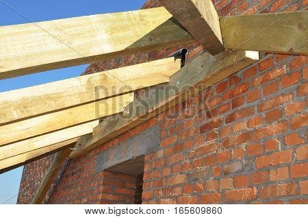 Roof trusses. Close up on installation of wooden beams at construction the roof truss system of the house. Roofing Construction. Building Attic Interior.