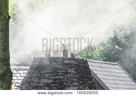 Smoking chimney on the roof of a house.