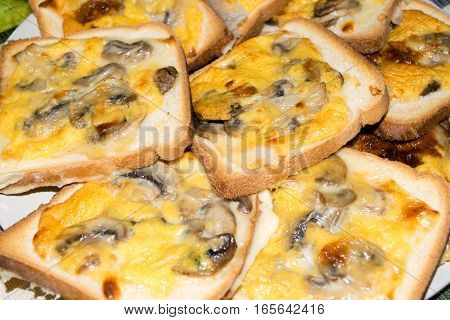 Slices of toasted white bread and seasoned with mushrooms, cheese and egg
