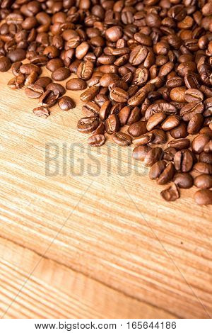 Roasted Coffee Beans Spread Over On Wooden Table.