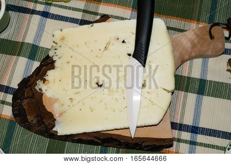 Cutting board with slice of pecorino cheese