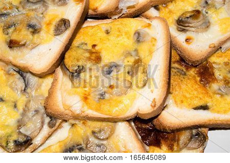 Slices of toasted white bread and seasoned with mushrooms, cheese and egg
