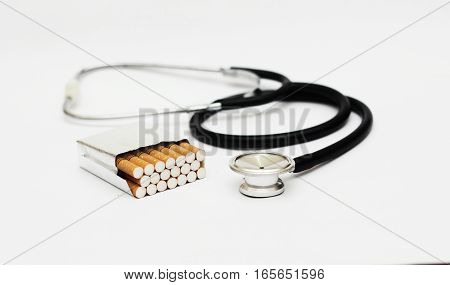 stethoscope and cigrettes on a white surface and background