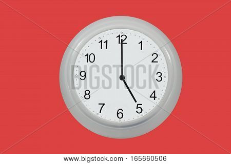 Wall watch showing five o'clock isolated on red background