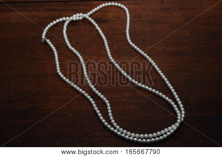 Pearl jewelry female necklace on wooden background