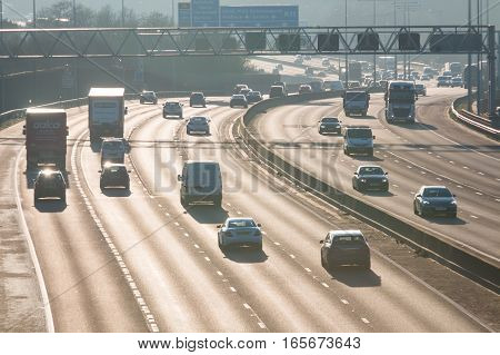 London, UK - January 18, 2017: Busiest British motorway M25 with cars and lorries in a foggy sunset time.