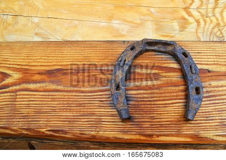 old horseshoe hanging on wooden wall. It brings happiness abundance and prosperity in the family. space for text