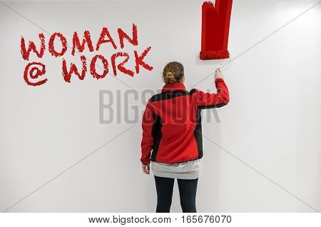 Female Painter With Red Paint Roller In Front Of Wall As Template