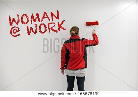 Female Painter With Red Paint Roller In Front Of Wall As Template