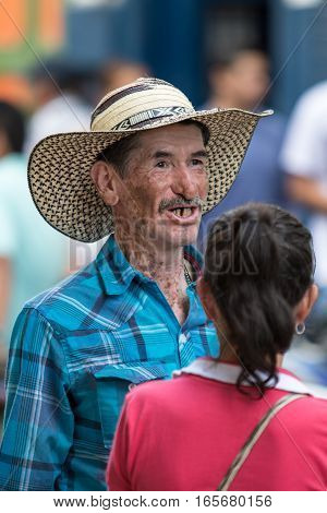 October 2, 2016 El Jardin, Colombia: a man with traditional straw hat called sombrero vueltiao having a conversation on the street of the colonial coffee growing town