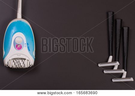 electric epilator with a razor on a dark background.