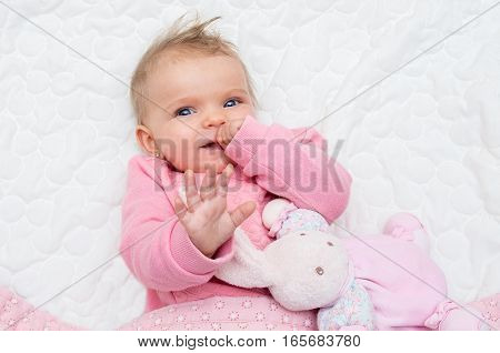 Happy Infant Baby Girl Smiling On Bed With His Toy Bunny