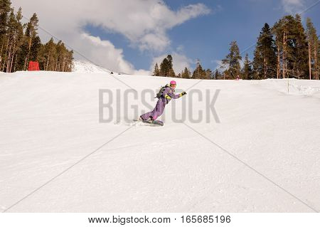 Beautiful beginner snowboarder girl in caucasian mountains